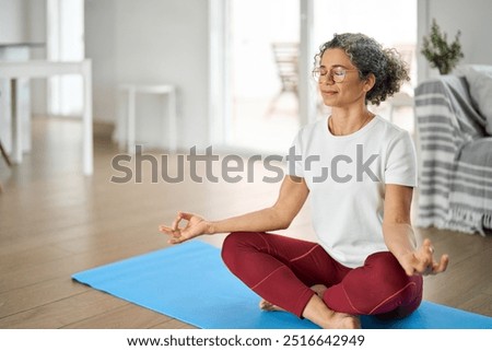 Similar – Image, Stock Photo An older woman is sitting on the sofa with a book. She is typing on her phone while smiling. She is protecting herself and staying home. Pandemic concept.