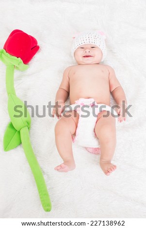 asian cute boy five month wearing a crochet hat on white carpet on white background