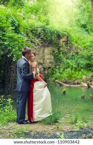 A young couple in love bride and groom at the picturesque bridge posing in their wedding day. Enjoy a moment of happiness and love. A series of photos in my portfolio.