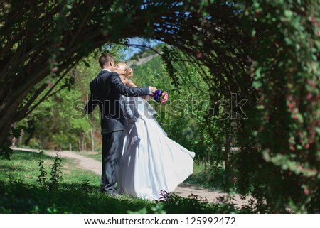 Beautiful bride and groom walk in the spring forest