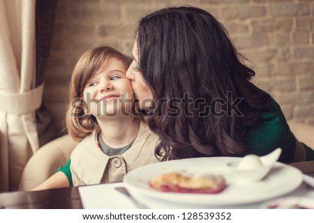 Mom and young daughter eating breakfast