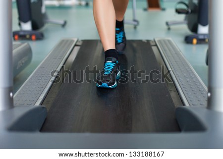 fitness woman legs on a treadmill in fitness sport club