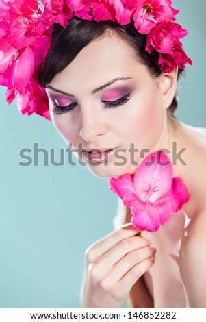 Beautiful Model Woman Face With Pink Flowers In Hair. Perfect Skin. Professional Make-up. Beauty and spa concept