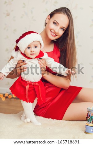 Portrait of happy mother and cute baby in suit of Santa\'s little helper