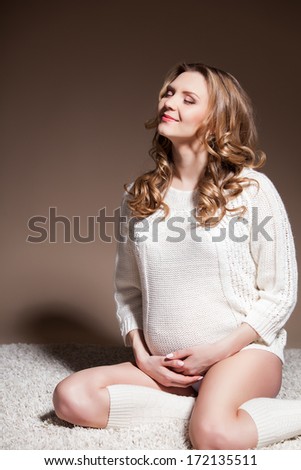 Beautiful pregnant woman wearing woolen accessories