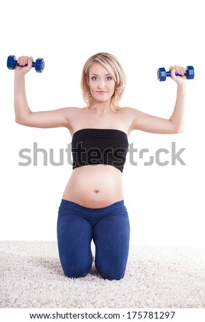 A pregnant woman exercising with a light weights - isolated. Workout indoors, sport for expectant female, healthy pregnancy concept