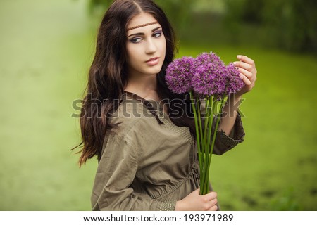 Beautiful Woman With Flowers Enjoying Nature against Nature Background