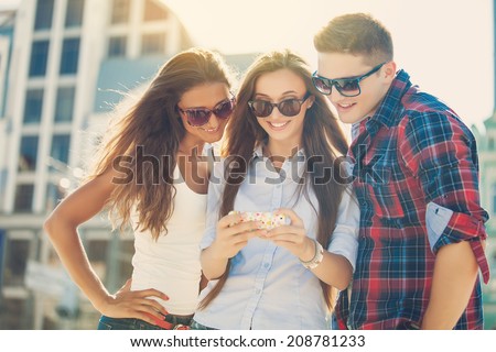 Friends amazed watching the smart phone outdoor