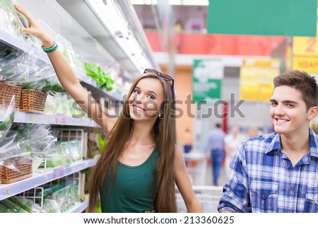 Young Family couple choosing fruit in vegetable supermarket during weekly shopping