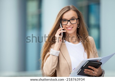 Successful businesswoman talking on cellphone while walking outdoor. City business woman working.