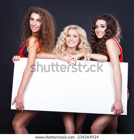 Cheerful sexy girls hold the blank placard with copy text. Greeting card