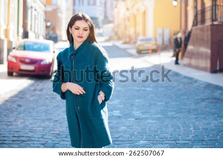 Day dreaming pretty brunette posing outdoors on urban background