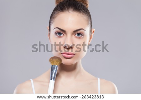 Beauty girl with makeup brushes. Perfect smooth skin.Applying makeup.