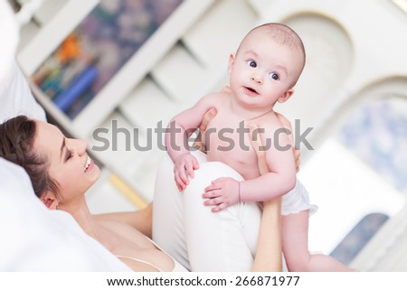 Happy family laughing faces, mother holding adorable child baby boy, smiling and hugging