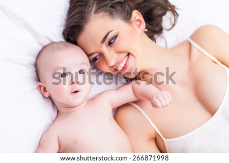 Happy family laughing faces, mother holding adorable child baby boy, smiling and hugging