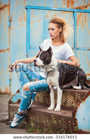 modern punk fashion, portrait of a beautiful model posing on the street with dog.  Modern Youth Lifestyle Concept