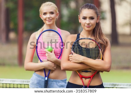 Beautiful female tennis players playing doubles at tennis at the tennis court
