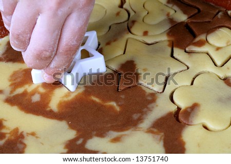 Spotty dough and star shape in hand, food background