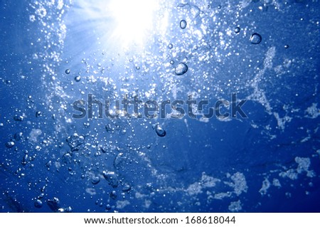 Under water air bubbles rising to water surface with sunlight in background, natural scene, Caribbean sea