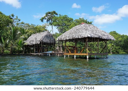 Waterfront property with thatched tropical hut and boathouse over the sea, Caribbean, Panama