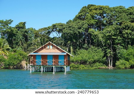 Bungalow over the sea with tropical vegetation in background, Caribbean, Bocas del Toro, Panama