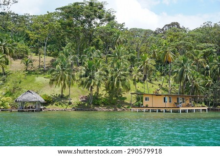 Oceanfront Caribbean property in Central America with coconut palm trees and a house with hut over water, Panama, Bocas del Toro