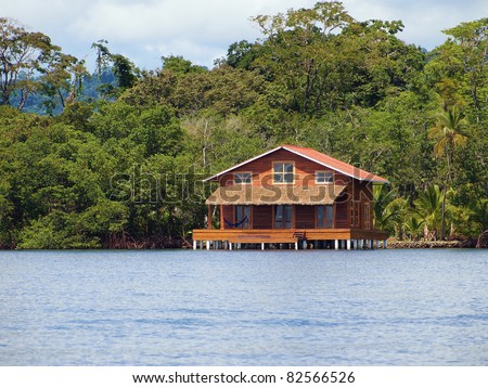 Tropical stilt house over the sea with jungle in background, Bocas del toro, Panama