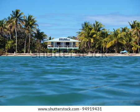 Tropical beach house with solar panels viewed from the Caribbean sea