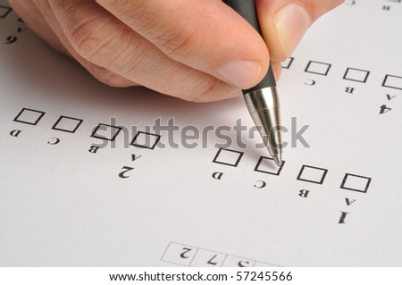 Macro of someone\'s hand filling exam answers form