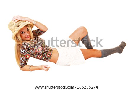 A slim pretty woman in a white skirt and gray socks and a beige straw hat lying on the floor for white background.
