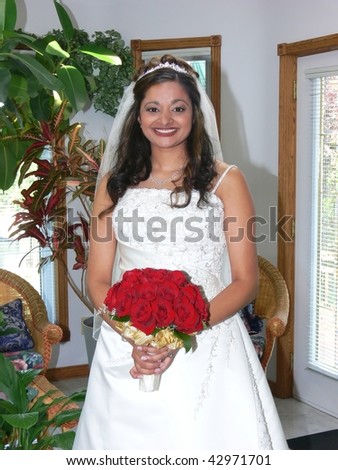 An portrait of the bride before she goes to church, in the sun room of her home.