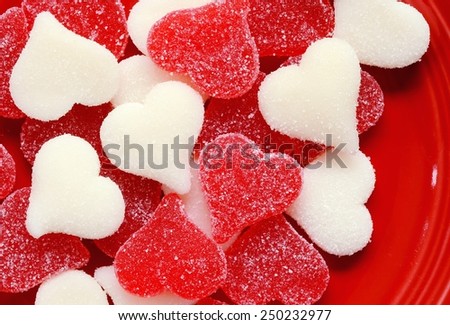Red and White sugared candy hearts on a red plate for Valentine\'s Day