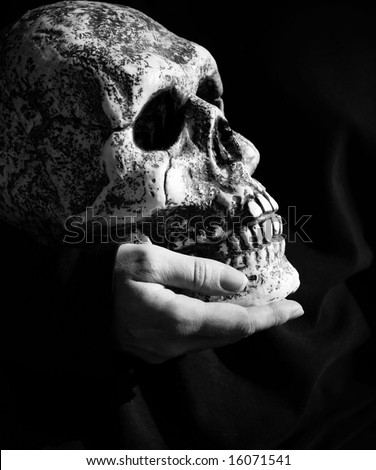 Halloween horror - hand holding a skull