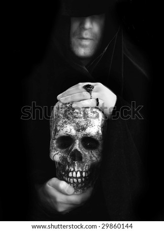 cloaked man holding skull