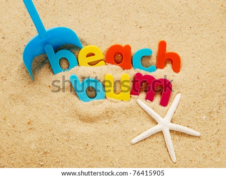 Beach bum written in colorful plastic letters with a shovel and starfish wedged in the sand