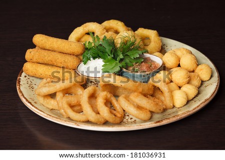A snack platter with popcorn and coconut shrimp, fries and beer