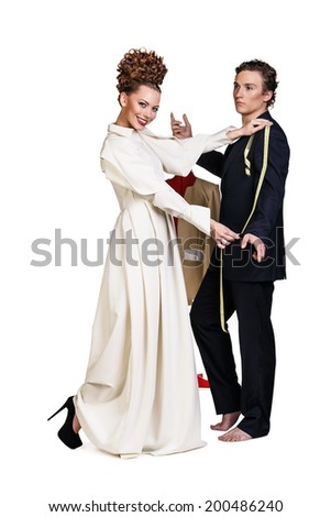 Stylish seamstress measuring a businessman for a suit or in order to alter the one he is wearing