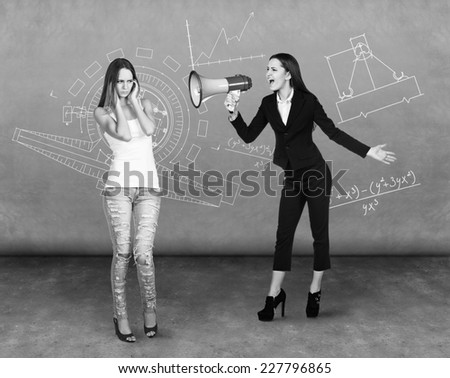 dissatisfied woman screaming at scared woman over dark background
