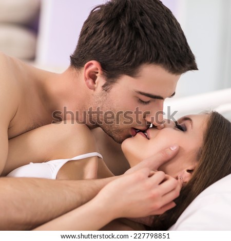 Young passionate couple making love in bed.  Focused on hand