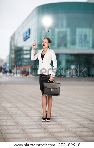 Full length portrait of a business woman walking with briefcase near office building. Idea concept