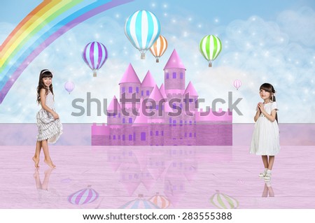 Two little girls in dresses in front of a pink fairy castle
