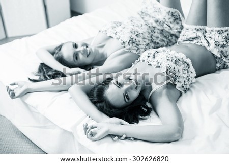 Closeup portrait of two beautiful women in the bed stretching theirself
