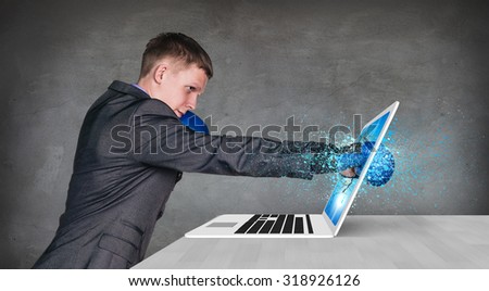 Serious businessman beats screen of laptop on the gray background
