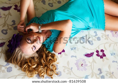 Portrait of an elegantly beautiful young woman in turquoise dress posing on the floor