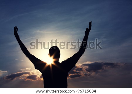 man with arms wide open is looking at the sky