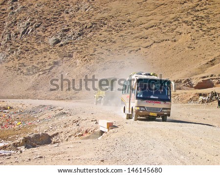 318 NATIONAL ROAD SHIGATSE LHASA, TIBET- NOVEMBER 17: local bus approaching a service station. This is one of the Tibet most important road. November 17, 2004 318 National Road, Tibet