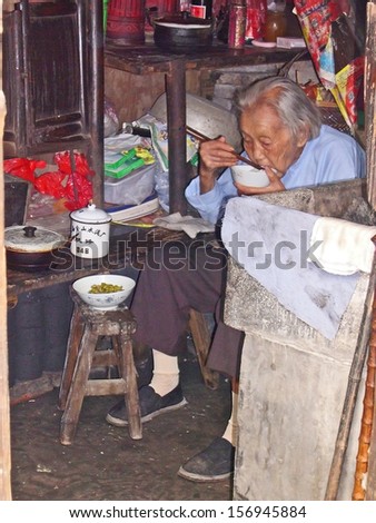 FENGJING, SHANGHAI, CHINA  SEPTEMBER 19: old lady eating lunch at her house. The ancient village is a Shanghai tourist attraction with 100000 visitors per year. September 19, 2004, Fengjing, China