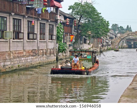 FENGJING, SHANGHAI, CHINA  SEPTEMBER 19: boats traffic in the main canal. The ancient village is a Shanghai tourist attraction with 100000 visitors per year. September 19, 2004, Fengjing, China