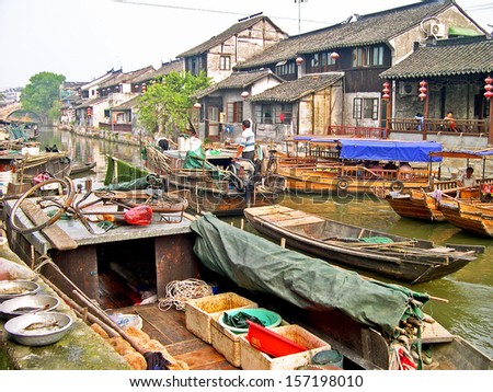 FENGJING, SHANGHAI, CHINA - SEPTEMBER 19: boat and village life along the main canal. The ancient village is  Shanghai tourist attraction with 100000 visitors year. September 19, 2004, Fengjing, China