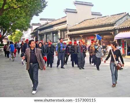 LUZHI, SHANGHAI, CHINA - OCTOBER 30: tourists walking in the village main street. The ancient village is a Shanghai tourist attraction with 100000 visitors per year. October 30, 2004 Luzhi, China.